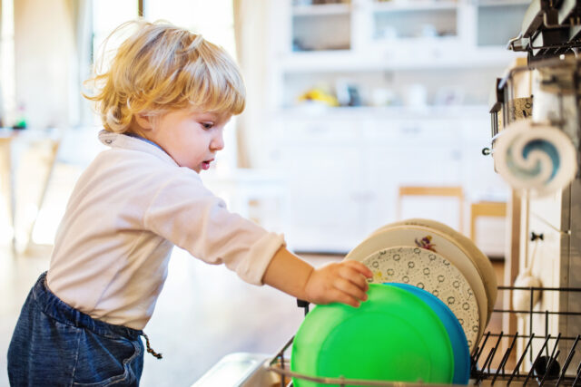 Toddler boy in dangerous situation at home. Child safety concept.