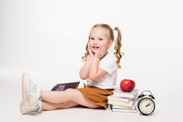 Beautiful shocked young girl lying on the floor isolated on white background