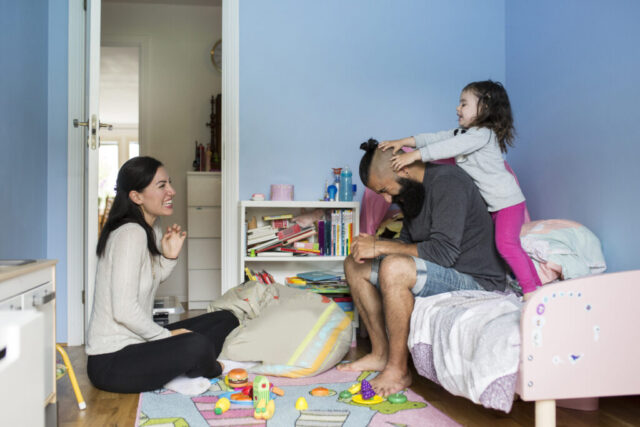 Mother and step-father playing with their daughter